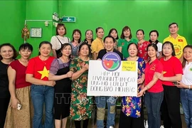 Representatives of the Vietnamese Association in Macau in a group photo with the token of their fund raised for victims of Typhoon Yagi in Vietnam (Photo: VNA)