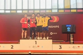 Tran Minh Tri of Vietnam (second left) takes two golds in the men's 67kg class at the World Youth Weightlifting Championships in Spain (Photo: VNA)