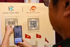 QR code scanning to enjoy the exhibition (Photo: VNA)