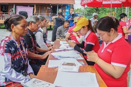 Co Tu ethnic minority people receive support to register SIM cards and install new cell phones (Photo: VNA)