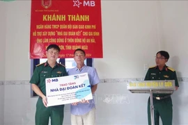 A representative of the Military Command of Ly Son district presents a Great Solidarity house to a poor household in the district's Dong Ho An Hai village in Quang Ngai province. (Photo: VNA)