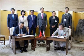 Chairman of the Hanoi People's Committee Tran Sy Thanh and Governor of Kanagawa Prefecture Kuroiwa Yuji sign the Memorandum of Understanding between the two localities. (Photo: VNA)