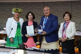 Deputy Minister of Health of Assoc. Prof. Nguyen Thi Lien Huong (2nd from left) receives a certificate and a plaque honouring Vietnam's elimination of trachoma. (Photo: nhandan.vn)