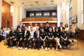 Ambassador Vu Quang Minh (with red tie) takes a photo with Vietnamese driver interns in Germany (Photo: VNA)