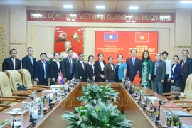 Participants of the two province pose for a group photo at the meeting. (Photo: VNA)