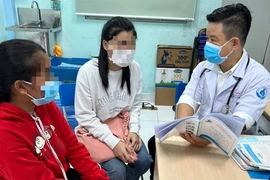 An adolescent patient with HIV receives a comprehensive medical evaluation and consultation from a doctor. (Photo moh.gov.vn)