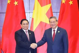 Prime Minister Pham Minh Chinh (L) shakes hands with Chinese Premier Li Qiang. (Photo: VNA)