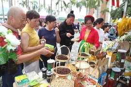 People visit the Vietnamese booth at the festival and try Vietnamese specialties. (Photo: VNA)