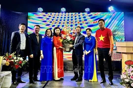 A flower basket is presented to new head of the Liaison Committee for Overseas Vietnamese in Europe “For Vietnam’s seas and islands” Bui Thi Thu Minh. (Photo: VNA)