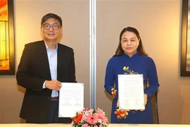 Vice Chairwoman and General Secretary of the VFF Central Committee Nguyen Thi Thu Ha (R) and Chief Executive Director of the People’s Association (PA) of Singapore Jimmy Toh exchange the MoU. (Photo: VNA)