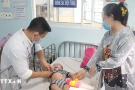 Treating a baby infected with measles (Photo: VNA)