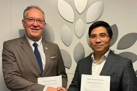 VNEI Chairman Nguyen Trung Dung (R) and CICAN Vice President Alain Roy pose for a photo after signing the cooperation agreement. (Photo: VNA)