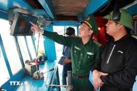 A representative from authority inspects the installation of vessel monitoring system (VMS) in a fishing vessel. (Photo: VNA)