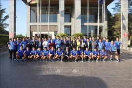 Representatives of the Vietnamese Embassy in Laos and the Vietnamese national men's football team pose for a group photo. (Photo: VNA)