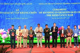 Keepsakes of Vietnamese war veterans and fallen soldiers are handed over to representatives of martyrs' families and veterans. (Photo: qdnd.vn)