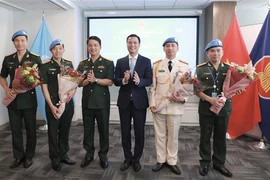 Ambassador Dang Hoang Giang (third from right) congratulates the military and public security officers working at the UN Department of Peace Operations at the ceremony in New York on May 24. (Photo: VNA)