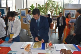 Delegates visit an exhibition of photos and documents about Vietnamese sea and islands on the sidelines of the workshop at the University of Warsaw on May 24. (Photo: VNA)