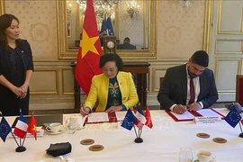 La ministra vietnamita del Interior, Pham Thi Thanh Tra, y el ministro francés de Función Pública, Simplificación y Transformación de Acción Pública, Guillaume Kasbarian, firman documentos de cooperación bilateral en materia de servicios públicos y modernización administrativa. (Foto: VNA)