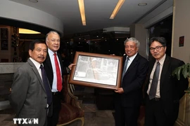 L'ancien directeur général de l'Agence vietnamienne d’Information (VNA) Tran Mai Huong (2e, droite)offre un cadeau de souvenir au secrétaire général du PT, Alberto Anaya Gutiérrez,. Photo : VNA