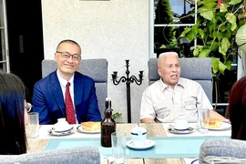 黎德阳先生向越南驻德国大使武光明分享两次与胡伯伯会面的纪念。图自越通社