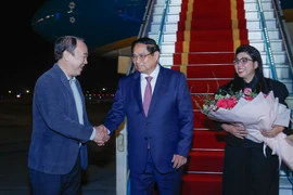 Prime Minister Pham Minh Chinh (C) and his spouse are welcomed by Vice Chairman of the Government Office Nguyen Sy Hiep at the Noi Bai International Airport. (Photo: VGP)