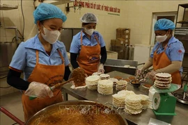 Workers make "cu do" - a candy made of roasted peanuts and molasses and covered with rice pancakes. The candy is a three-starred OCOP product of the central province of Ha Tinh. (Photo: VNA)
