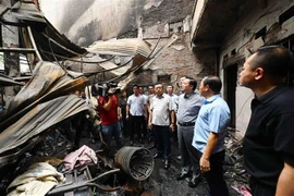 Deputy Prime Minister Tran Hong Ha (third, from right) at the fire scene. (Photo: VNA)
