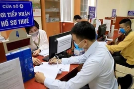 A tax official assists a man in filling out his tax returns in the capital city of Hanoi. (Photo: VNA) 