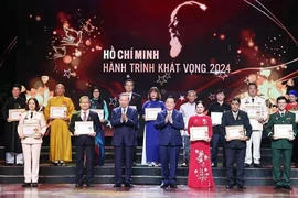 Party General Secretary To Lam (third from left, front row) and Politburo member, Secretary of the Party Central Committee and Chairman of the Party Central Committee's Commission for Information and Education Nguyen Trong Nghia (fourth from right, front row) present Certificates and Emblems to honour 25 typically outstanding models nationwide in studying and following President Ho Chi Minh's thought, morality and style. (Photo: VNA)