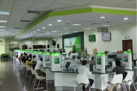 Customers make transactions at a Vietcombank’s office in Hanoi (Photo: VNA)