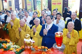 Prime Minister Pham Minh Chinh (second from the right, first row) and Vietnam Buddhist Sangha's dignitaries perform the traditional rituals of bathing the Buddha. (Photo: VNA)