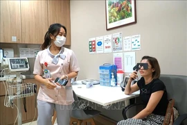 A person gets her eyes tested by a Sunway Medical Centre's staff. (Photo: VNA) 