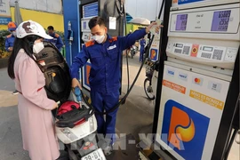 A woman buys petrol at a petrol station in Hanoi. (Photo: VNA)
