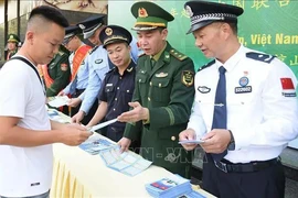 越中边防配合向在国际友谊口岸（越南）和友谊关（中国）出入境的人们发放宣传单。图自越通社 