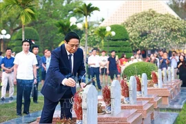 Le Premier ministre Pham Minh Chinh allume de l'encens sur des tombes au Cimetière national des martyrs A1. Photo: VNA