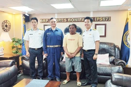 Des cadres du navire 412 et le pêcheur philippin Allan Maglangit (maillot jaune). Photo: VNA