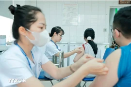 Vaccination de personnes au Centre de contrôle des maladies de Hanoï. Photo: VNA