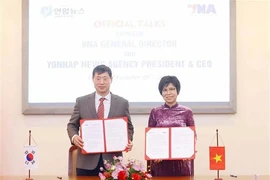 General Director of the Vietnam News Agency Vu Viet Trang (right), and President and CEO of the Republic of Korea (RoK)’s Yonhap News Agency Hwang Dae-il sign the minutes of their talks in Hanoi on December 10. (Photo: VNA)