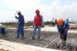 干部们检查北南高速公路建设项目经过富安省的达朗（Đà Rằng）桥施工现场劳动安全卫生保障情况。图自越通社