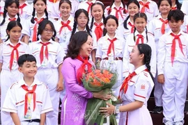 胡志明市少年向国家副主席武氏映春送花。图自越通社