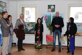 La peintre Kim Doan (au milieu) au vernissage de son exposition à Bruxelles. Photo: VNA