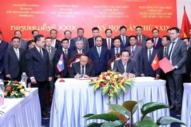 El viceministro de Defensa y jefe del grupo de trabajo vietnamita, el teniente general Vo Minh Luong (derecha), y el viceministro de Defensa y jefe del grupo de trabajo de Laos, el teniente general Thongloi Silivong, firman el acta de la reunión. (Foto: VNA)