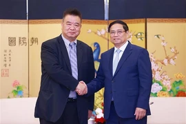 El primer ministro de Vietnam, Pham Minh Chinh y Cao Ronggen, presidente del Centro Internacional de Subastas de Flora de Kunming (KIFA) (Fuente: VNA)