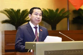 Chairman of the NA’s Finance-Budget Committee Le Quang Manh briefs the NA on the adjustments that NA Standing Committee has made to the draft resolutions. (Photo: VNA)