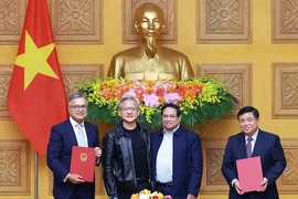 PM Pham Minh Chinh (second from right) and NVIDIA President and CEO Jensen Huang (third from right) witness the signing ceremony of the agreement between the Vietnamese Government and the US giant tech. (Photo: VNA)