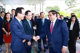 Руководители Samsung приветствуют премьер-министра Фам Минь Тьиня (справа) на полупроводниковом кластере группы в провинции Кёнги. (Фото: ВИA)
