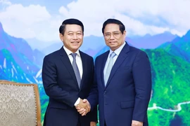 Премьер-министр Фам Минь Тьинь (справа) и заместитель премьер-министра и министр иностранных дел Лаоса Салеумксай Коммаситх на встрече в Ханое 5 июля (Фото: ВИA)
