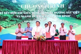 Представители Департамента туризма Ниньбиня и Вьетнамской железнодорожной корпорации демонстрируют подписанный Меморандум о сотрудничестве. (Фото: ВИA)