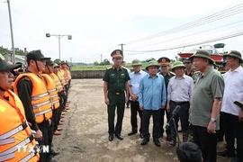 Генеральный секретарь партии, президент государства То Лам (второй справа) посещает силы, укрепляющие важный участок дамбы на реке Ло в общине Чыонгшинь уезда Шонзыонг провинции Туенкуанг 12 сентября. (Фото: ВИA)