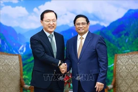 Le Premier ministre Pham Minh Chinh (à droite) serre la main du directeur financier de Samsung Electronics Park Hark-kyu, à Hanoi, le 9 mai. Photo: VNA